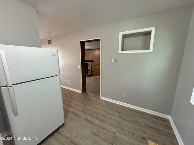 kitchen with hardwood / wood-style flooring, a fireplace, and white refrigerator