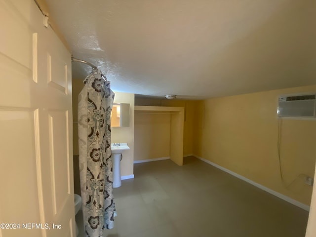 bathroom with a wall mounted AC and a shower with curtain