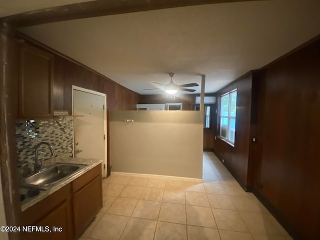 kitchen featuring backsplash, crown molding, sink, and light tile patterned floors