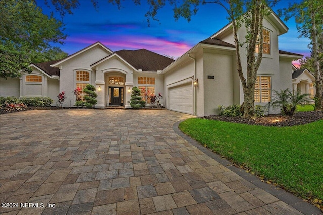 view of front of property featuring a garage and a lawn