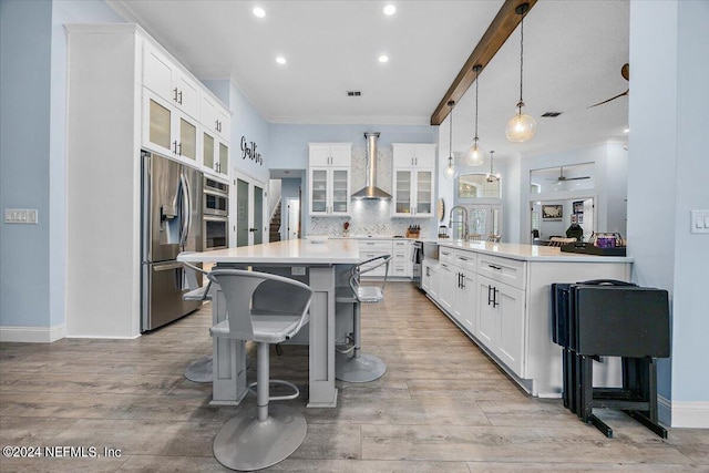 kitchen featuring hanging light fixtures, white cabinetry, kitchen peninsula, stainless steel appliances, and ceiling fan