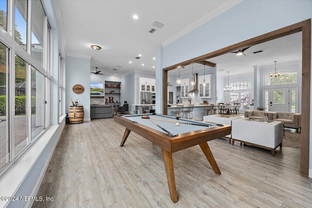 game room with light wood-type flooring, crown molding, pool table, and a chandelier