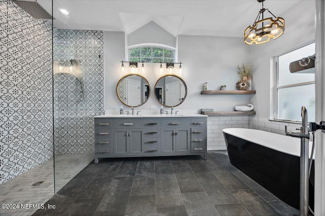 bathroom with vanity, lofted ceiling, a textured ceiling, plus walk in shower, and tile walls