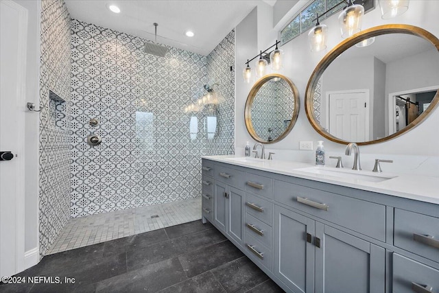 bathroom with tile patterned floors, vanity, and tiled shower