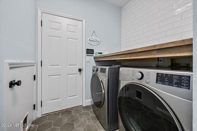 laundry area featuring separate washer and dryer and dark tile patterned floors