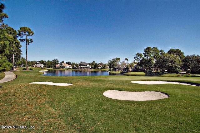 surrounding community featuring a lawn and a water view