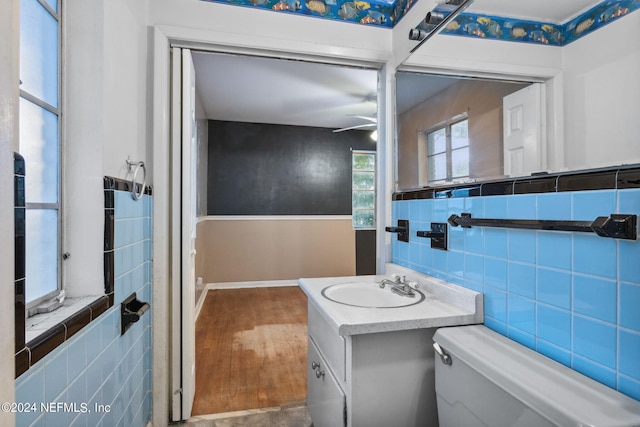 bathroom with tile walls, vanity, toilet, and hardwood / wood-style flooring