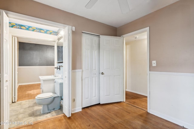 bedroom with connected bathroom, hardwood / wood-style floors, and ceiling fan