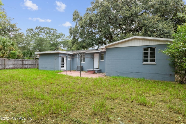 6124 Sudbury Ave S, Jacksonville, FL 32210 - rear view of property with fence, central air condition unit, a patio, a lawn, and concrete block siding