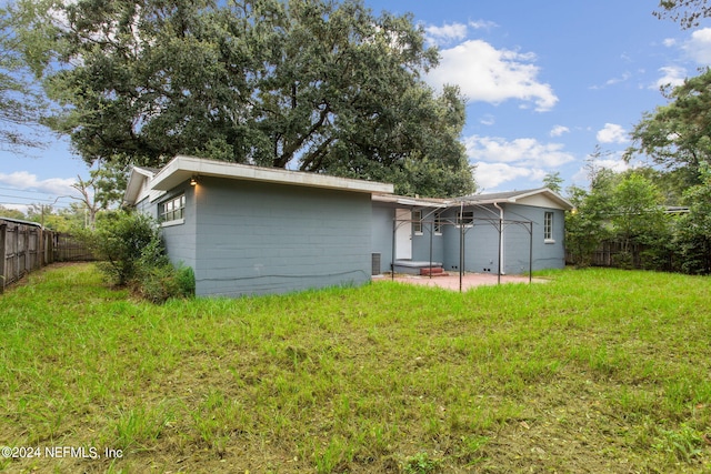 6124 Sudbury Ave S, Jacksonville, FL 32210 - back of property featuring a fenced backyard, concrete block siding, a patio area, and a yard