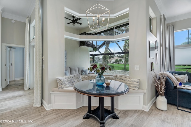 interior space with ceiling fan with notable chandelier, light wood-type flooring, and ornamental molding