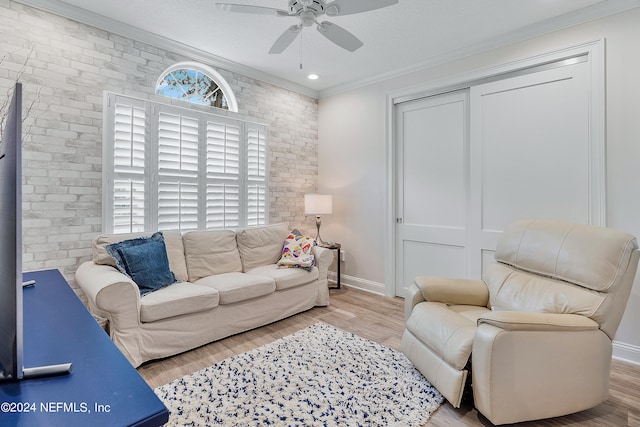 living room with ceiling fan, a textured ceiling, light wood-type flooring, and crown molding