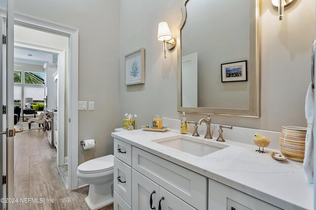 bathroom featuring vanity, hardwood / wood-style floors, and toilet