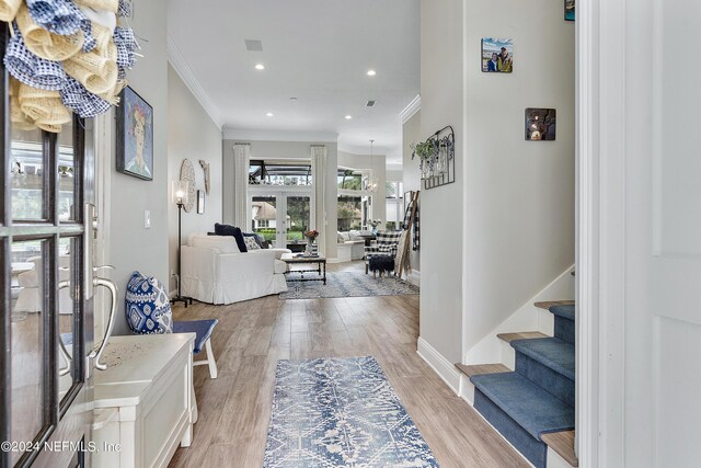 foyer with light hardwood / wood-style flooring and crown molding