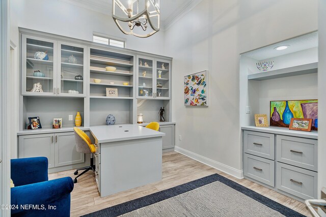 office with ornamental molding, light hardwood / wood-style floors, and a notable chandelier