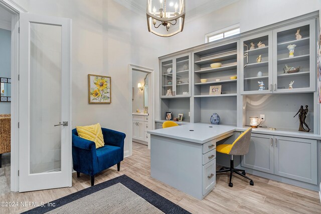 office featuring light hardwood / wood-style floors, ornamental molding, and a notable chandelier