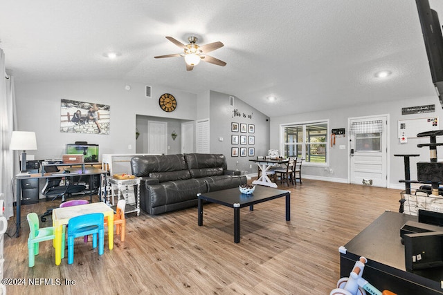 living room featuring ceiling fan, lofted ceiling, and light wood-type flooring