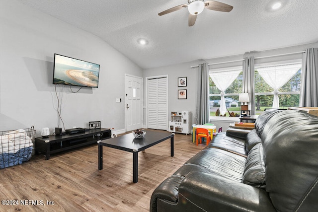 living room with a textured ceiling, vaulted ceiling, ceiling fan, and hardwood / wood-style flooring