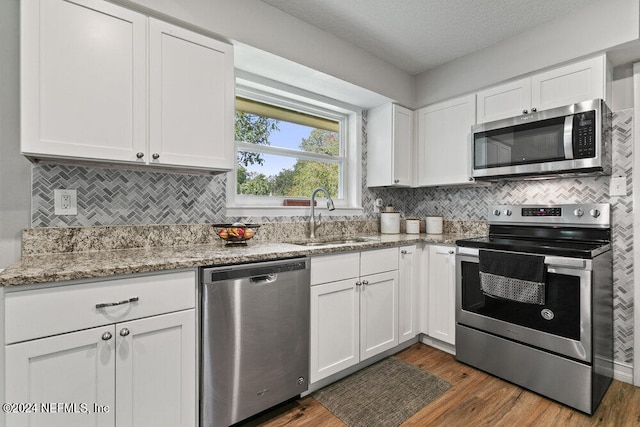 kitchen with sink, a textured ceiling, white cabinetry, stainless steel appliances, and dark hardwood / wood-style flooring