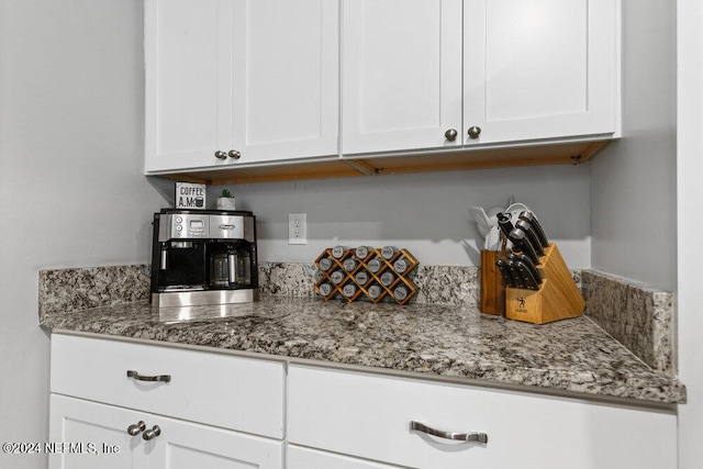 kitchen with light stone countertops and white cabinetry