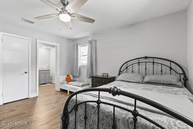 bedroom with wood-type flooring, ceiling fan, and a textured ceiling