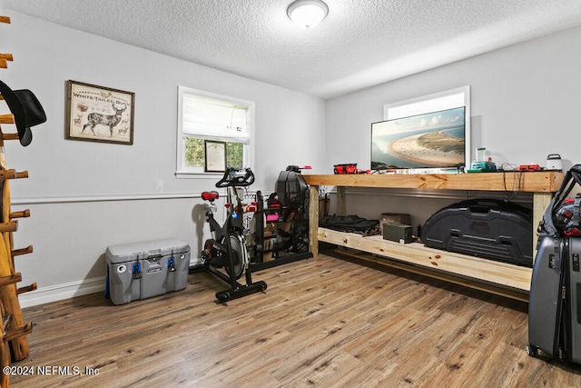 exercise room featuring hardwood / wood-style flooring and a textured ceiling