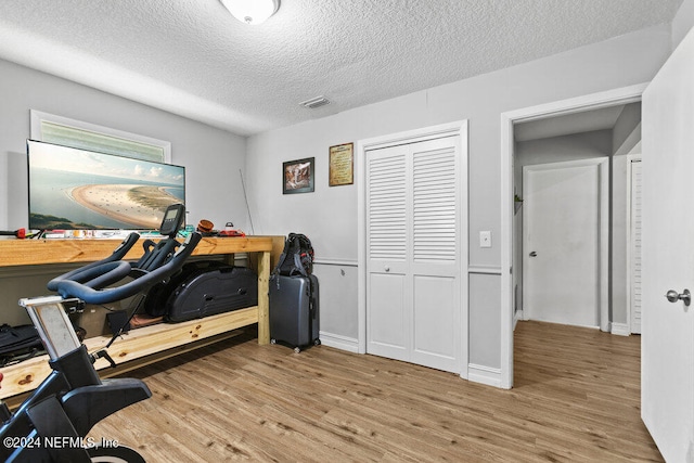 workout area featuring a textured ceiling and hardwood / wood-style flooring