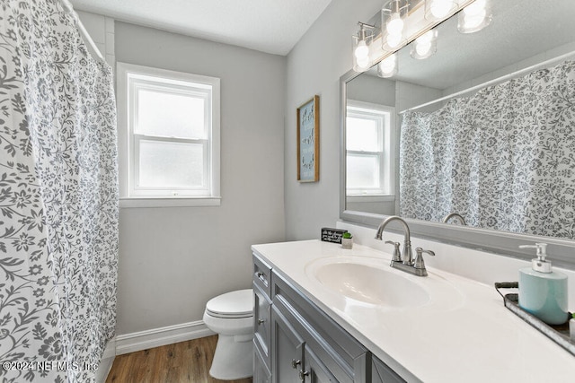 bathroom with wood-type flooring, a textured ceiling, vanity, and toilet