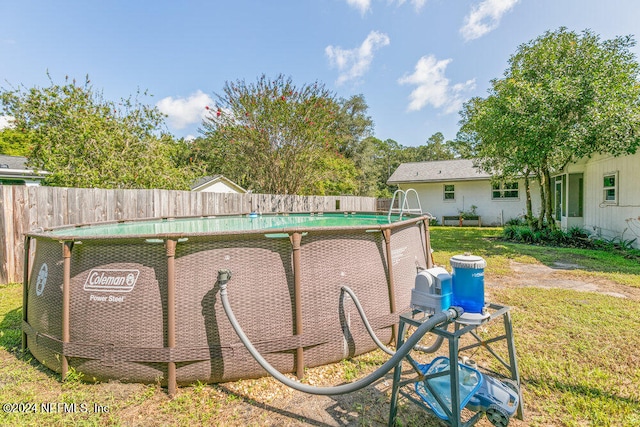 view of pool with a yard