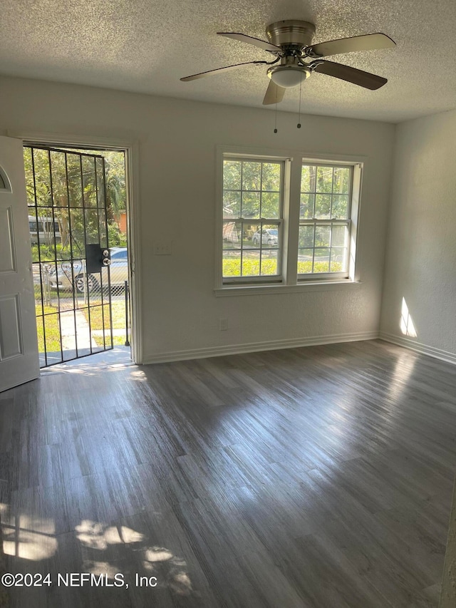 unfurnished room featuring ceiling fan, a textured ceiling, and dark hardwood / wood-style flooring