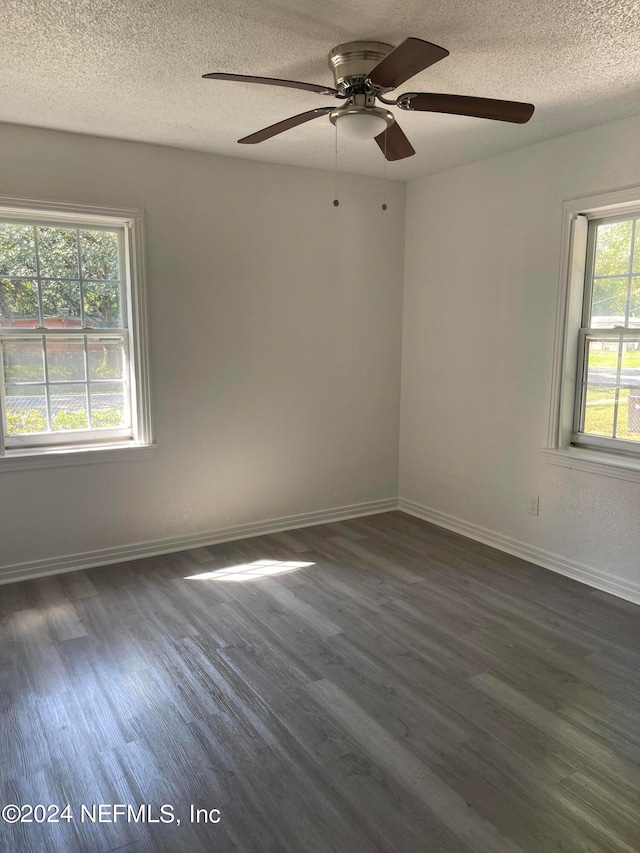 unfurnished room with ceiling fan, dark wood-type flooring, and a textured ceiling