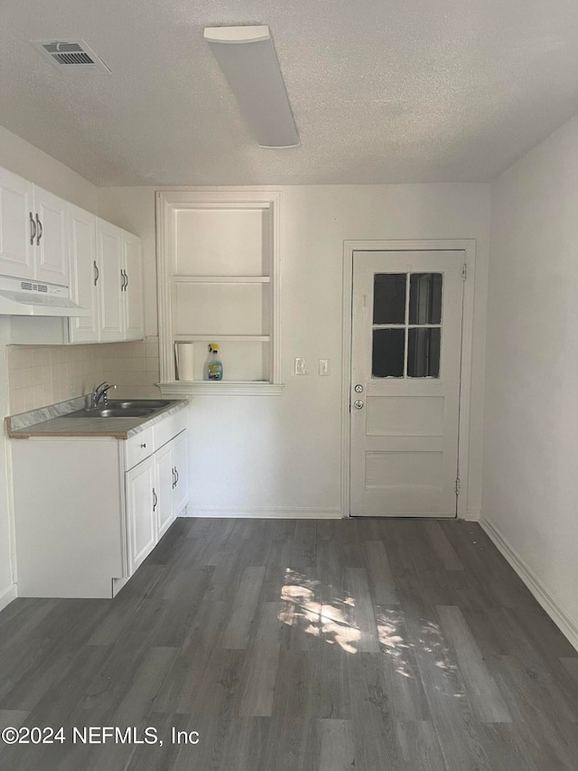 kitchen featuring a textured ceiling, white cabinetry, dark hardwood / wood-style floors, and tasteful backsplash