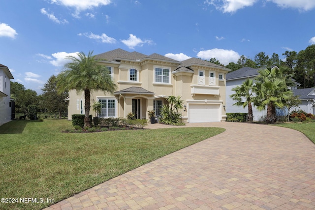 mediterranean / spanish house with a garage and a front lawn