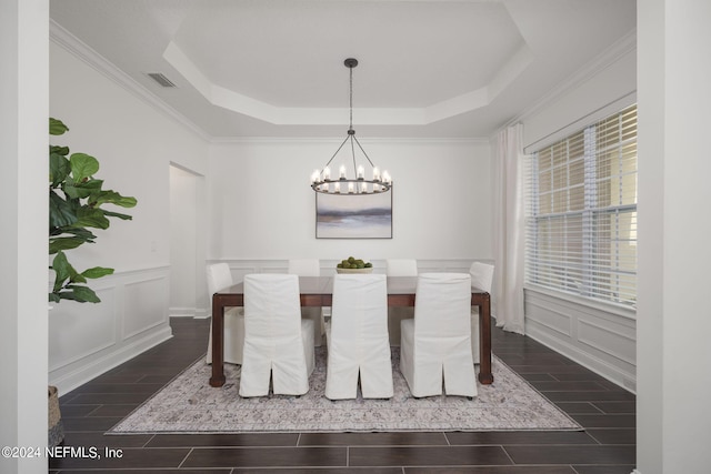 dining space with dark hardwood / wood-style floors, a raised ceiling, crown molding, and a notable chandelier