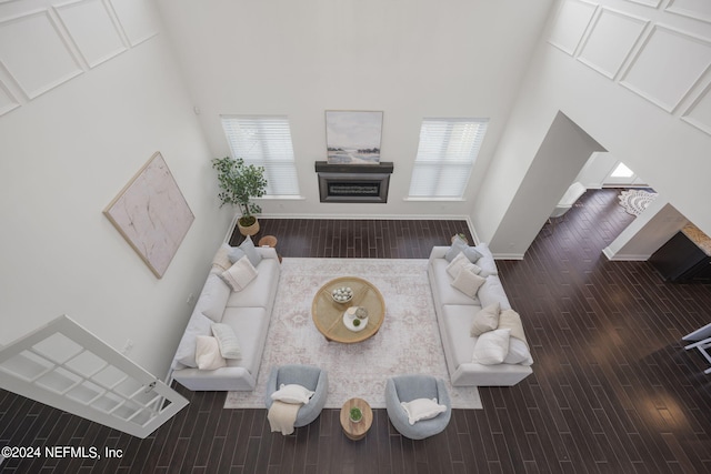 living room with hardwood / wood-style floors and a towering ceiling