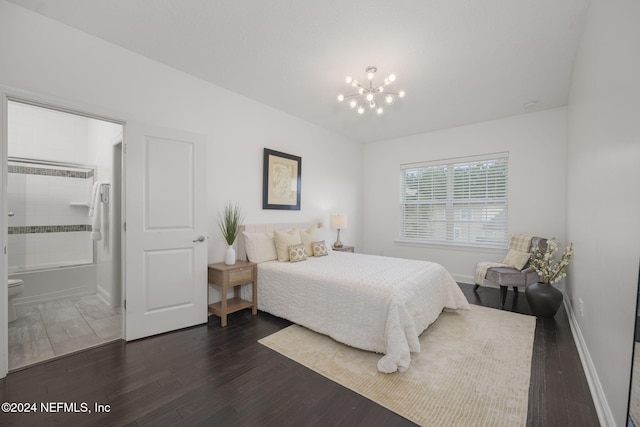 bedroom with ensuite bathroom, dark wood-type flooring, and an inviting chandelier