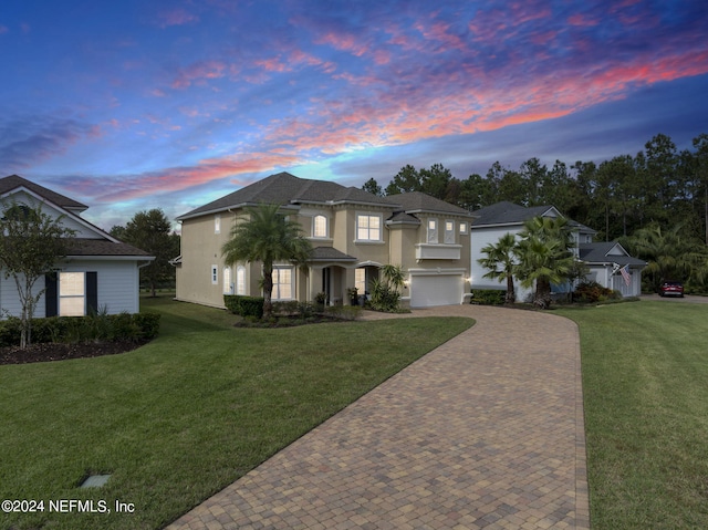 view of front of property with a yard and a garage