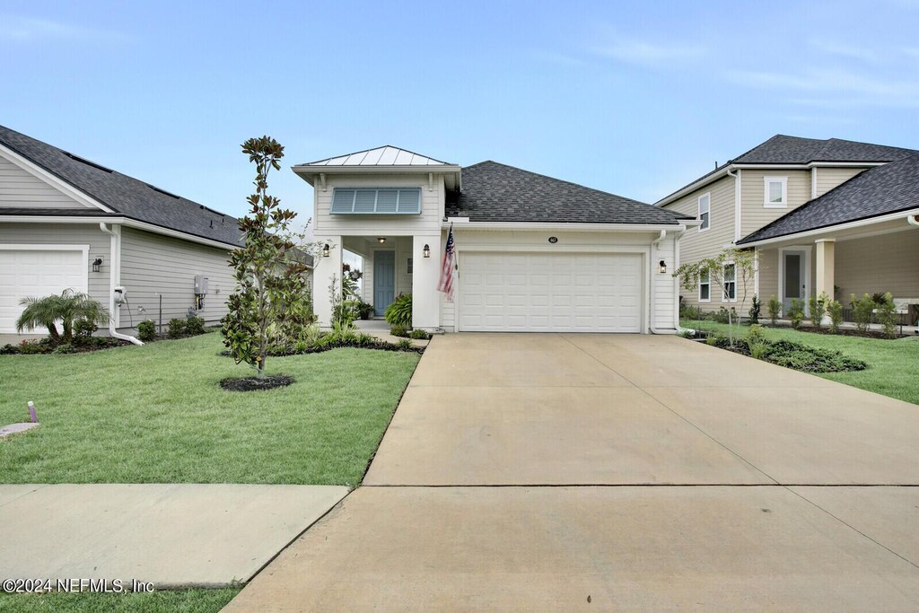 view of front of property with a garage and a front lawn