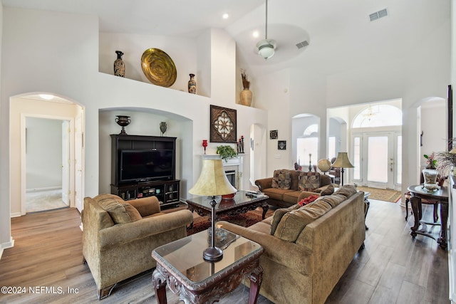 living room featuring high vaulted ceiling, light wood-type flooring, and ceiling fan