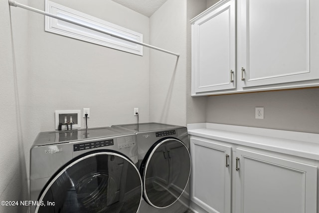 laundry area with separate washer and dryer, cabinets, and a textured ceiling