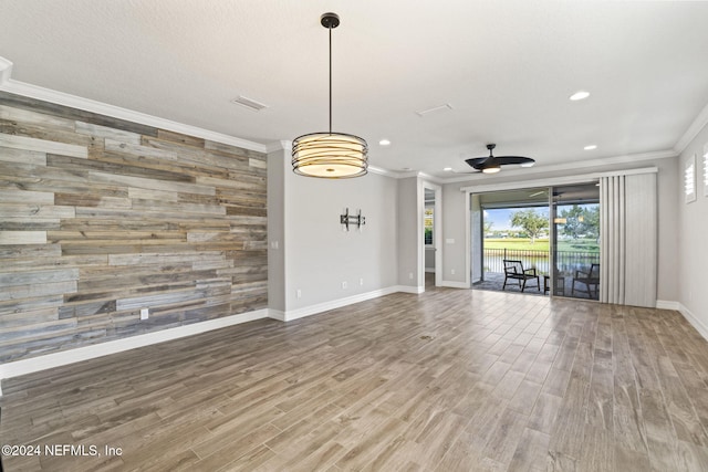 unfurnished living room with crown molding, hardwood / wood-style floors, and ceiling fan