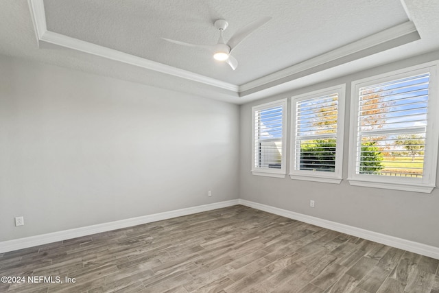 spare room with a raised ceiling, ceiling fan, a textured ceiling, and hardwood / wood-style flooring