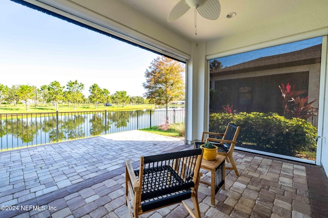 view of patio / terrace featuring ceiling fan and a water view