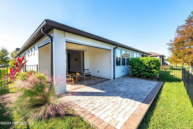 back of house featuring a patio and a lawn