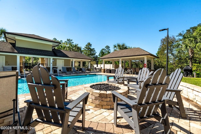 view of swimming pool featuring a gazebo, a fire pit, and a patio area