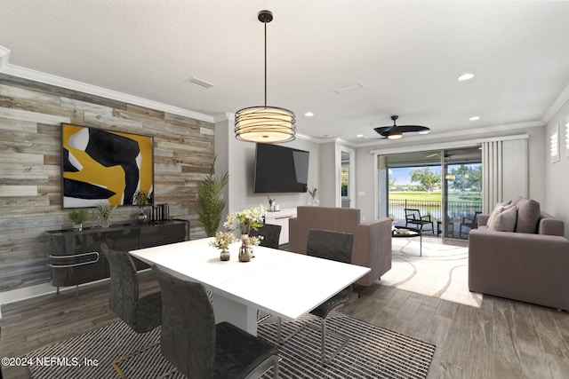 dining room featuring dark hardwood / wood-style flooring, ceiling fan, crown molding, and wood walls