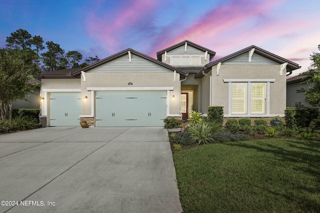 view of front of property featuring a lawn and a garage