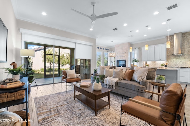 living room with light hardwood / wood-style flooring, ceiling fan, and crown molding