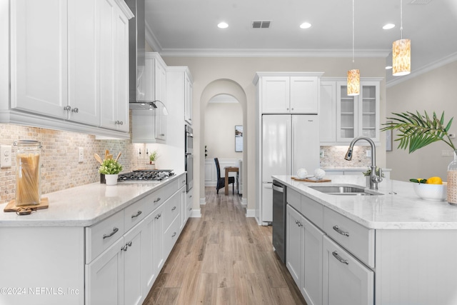 kitchen featuring sink, white cabinets, hanging light fixtures, and ornamental molding