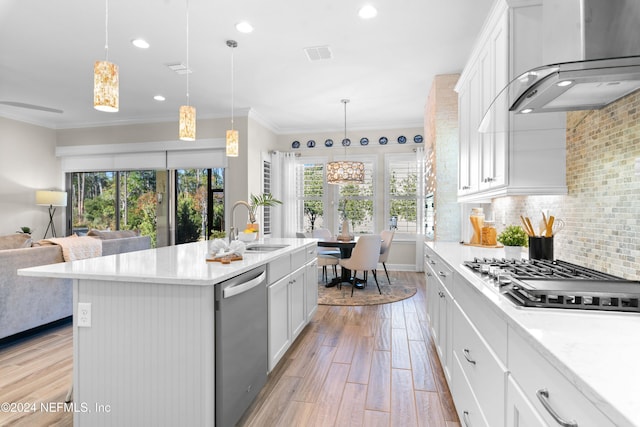 kitchen with white cabinetry, wall chimney range hood, light hardwood / wood-style flooring, a center island with sink, and appliances with stainless steel finishes